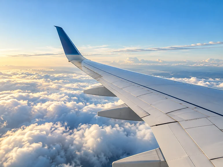 Aircraft wing above the clouds at sunrise